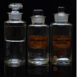 Three chemists/ pharmacy glass apothecary bottles with labels including Quin Bisulp, largest 17.