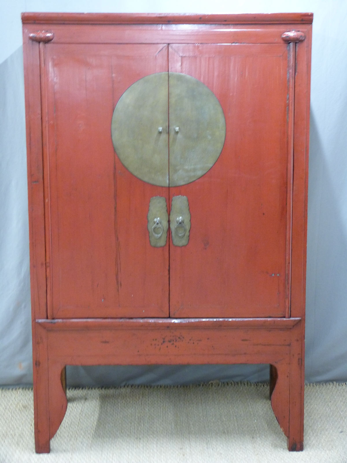 Chinese red lacquer cupboard with brass mounts, the interior with two drawers, shelves and secret