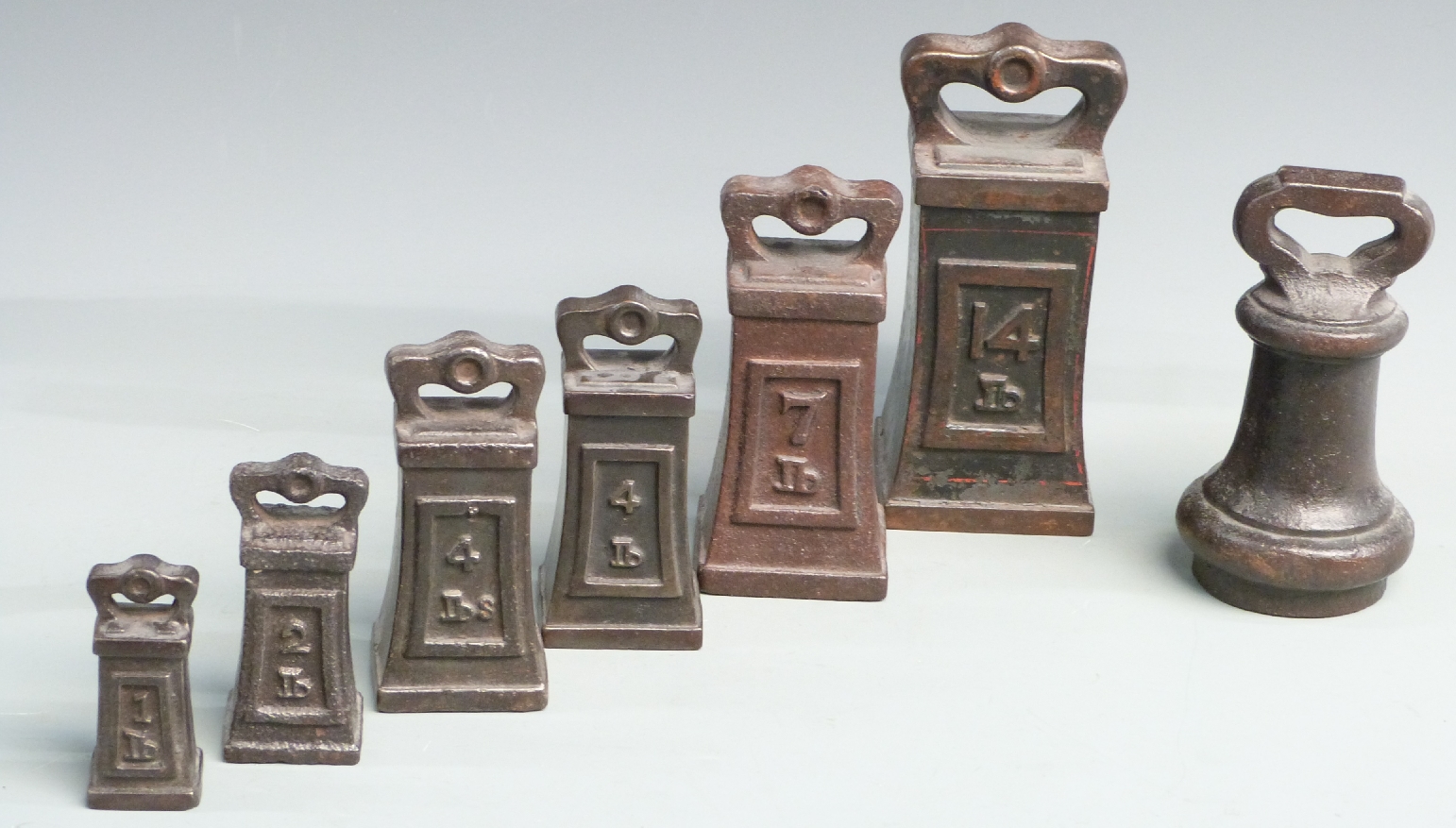 A run of six square waisted cast iron weights from 14lb to 1lb, together with a circular 7lb