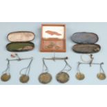 Three cased sets of travelling beam scales including apothecary and similar weights