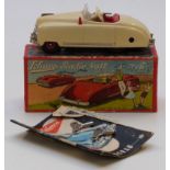 Schuco Radio 4012 clockwork tinplate car car with cream body and red interior containing a Thorens