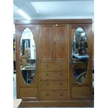 Edwardian mahogany Sheraton style triple wardrobe set with ornate inlay of scrolling fauna, the