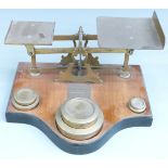 Victorian brass parcel scales on wooden base with flat stacking weights from 4lb down to 2oz,