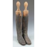 A pair of vintage leather riding boots with trees, approximately size 8