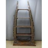 Indian or similar Eastern bookcase, the vertical support formed from horse hames with brass and