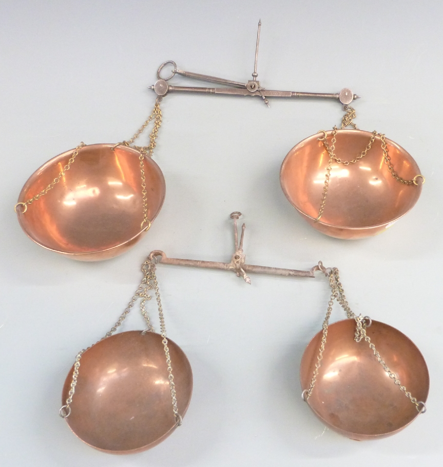 Two travelling beam scales with copper pans, one marked Avery, width of larger 26cm