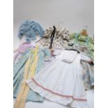 Seven childrens or large dolls' dresses and outfits, most with floral patterns