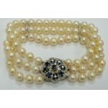 A three strand cultured pearl bracelet with 9ct white gold clasp set with nine round cut