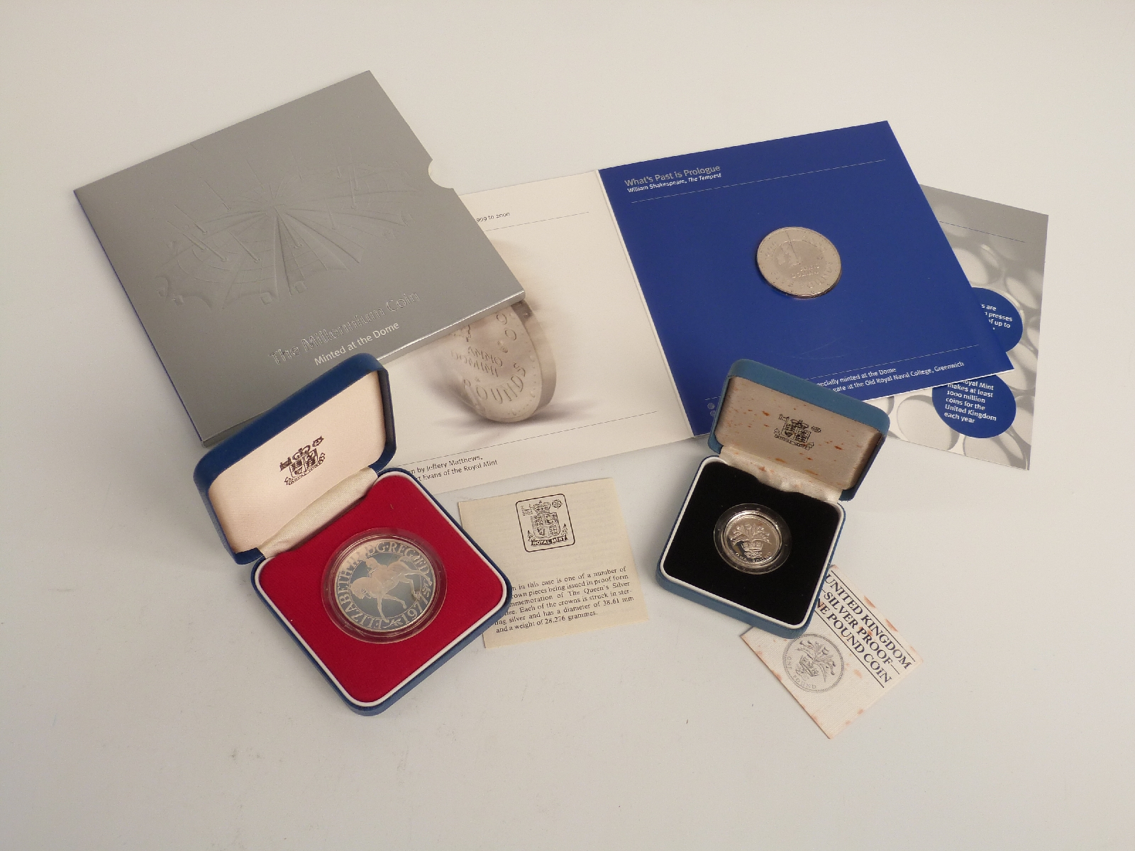 A £5 millennium crown in presentation pack, together with a UK silver proof £1 coin and a silver