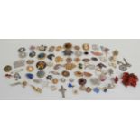 A collection of brooches including a DWH Scotland brooch, enamel brooches, Sarah Coventry brooch