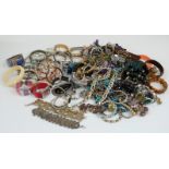 A collection of costume jewellery including beaded necklaces, silver bangles, silver curb link