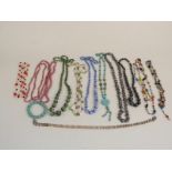 A collection of necklaces including a silver necklace made up of circular links, pearl, glass, agate