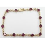 A 9ct gold tennis bracelet set with garnets, 5.8g