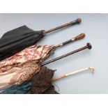 A collection of Edwardian lace parasols including lace, white metalmounted and gold stud inlaid
