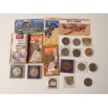 A collection of various crowns and commemorative coins, some in presentation packs