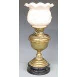 Brass oil lamp on black lacquered pottery base, the pale pink milk glass shade with embossed