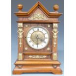 Architectural oak cased mantel clock with ivory coloured Roman chapter ring, brass decoration,