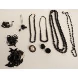 A collection of jet jewellery including faceted beaded necklaces, a brooch set with a cameo by B H