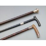 Three silver and white metal mounted walking canes, London 1924 the other two unmarked, one having