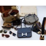 A collection of handbags including a large clutch bag with applied Moschino, designer leather belts,