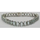 A white metal tennis bracelet set with 31 oval aquamarines each approximately 0.44ct (total approx