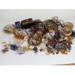 A collection of costume jewellery including beads, vintage earrings, vintage brooches, lacquer