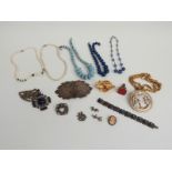 A collection of jewellery to include a white metal buckle, glass beads, ceramic beads, Les Bernard