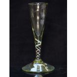 An 18thC clear glass drinking glass with red, white and blue twist decoration to the stem, raised on