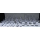 A suite of 53 clear glass drinking glasses all raised on hexagonal bases, largest 15cm tall