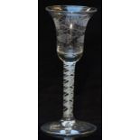 An 18thC clear glass drinking glass with engraved bell shaped bowl and white twist decoration to the