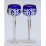 A pair of flash overlaid cut glass hock glasses with blue overlay over clear ground, gilt rims,