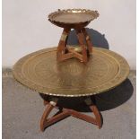 A large Eastern brass portable table with embossed detail on collapsible base together with a