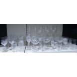 Sixty clear glass drinking glasses including six champagne flutes, sets of wine glasses, beakers