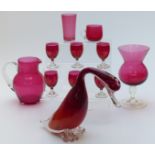 Eleven pieces of cranberry glass including jug, vase, duck etc, largest piece 21cm tall