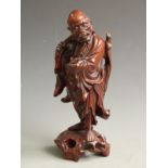 A carved Chinese hardwood figure of an elder with bone teeth and eyes, 30cm