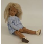 Sasha doll with pink lips, blue eyes, blue eyeshadow, blonde hair, check outfit and leather shoes,