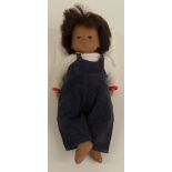 Sasha doll with pink lips, brown eyes, blue eyeshadow, brown hair, blue dungarees and white top,