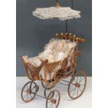 A childs dolls pram, with wicker basket and lace parasol together with three dolls and a Teddy Bear