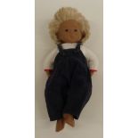 Sasha doll with pink lips, brown eyes, blue eyeshadow, blonde hair, blue dungarees and white top,