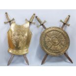 Two brass shield and crossed sword wall hangings, height 75cm