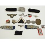 A small collection of WWII Nazi German badges and cloth insignia including a Waffen SS