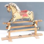 Vintage rocking horse with dappled decoration and upholstered saddle on wooden base, height 91cm,