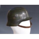 German Army WWII steel helmet with single decal to side, stamped SE62 complete with leather liner