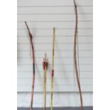 A yew wood long bow, two other bows and a quantity of arrows, longest 160cm