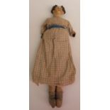 A lacquer headed doll with moulded hair, painted features, soft body and leather hands, in