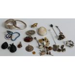 A collection of jewellery including a pressed amber brooch, a silver bangle, two jet earrings, a