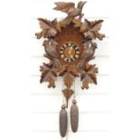 Black Forest German two train cuckoo clock with carved woodpecker decoration, 45cm tall