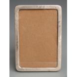 George V hallmarked silver photograph frame to suit 5.5x3.5 inch photo, with wooden easel back,