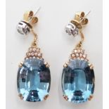 A pair of 14ct gold earrings set with a mixed cut aquamarine (measuring approx 7.6ct) and diamonds