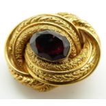 Victorian knot brooch with embossed textured design set with a foiled garnet, 7.7g (2.3 x 1.6cm)